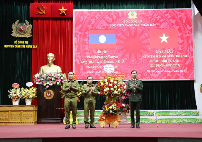Đại tá Hoàng Đại Nghĩa - Phó Cục trưởng Cục Đào tạo, Bộ Công an tặng hoa chúc mừng học viên Lào nhân dịp 48 năm ngày Quốc khánh nước CHDCND Lào