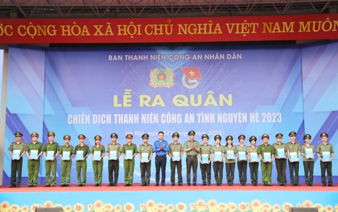 Trung tá Đồng Đức Vũ và đồng chí Nguyễn Kim Quy trao học bổng cho các học sinh, sinh viên các học viện, trường CAND có hoàn cảnh khó khăn và có thành tích xuất sắc trong năm học 2022 - 2023